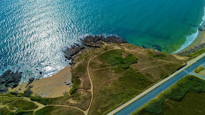 an aerial view of a road near the ocean